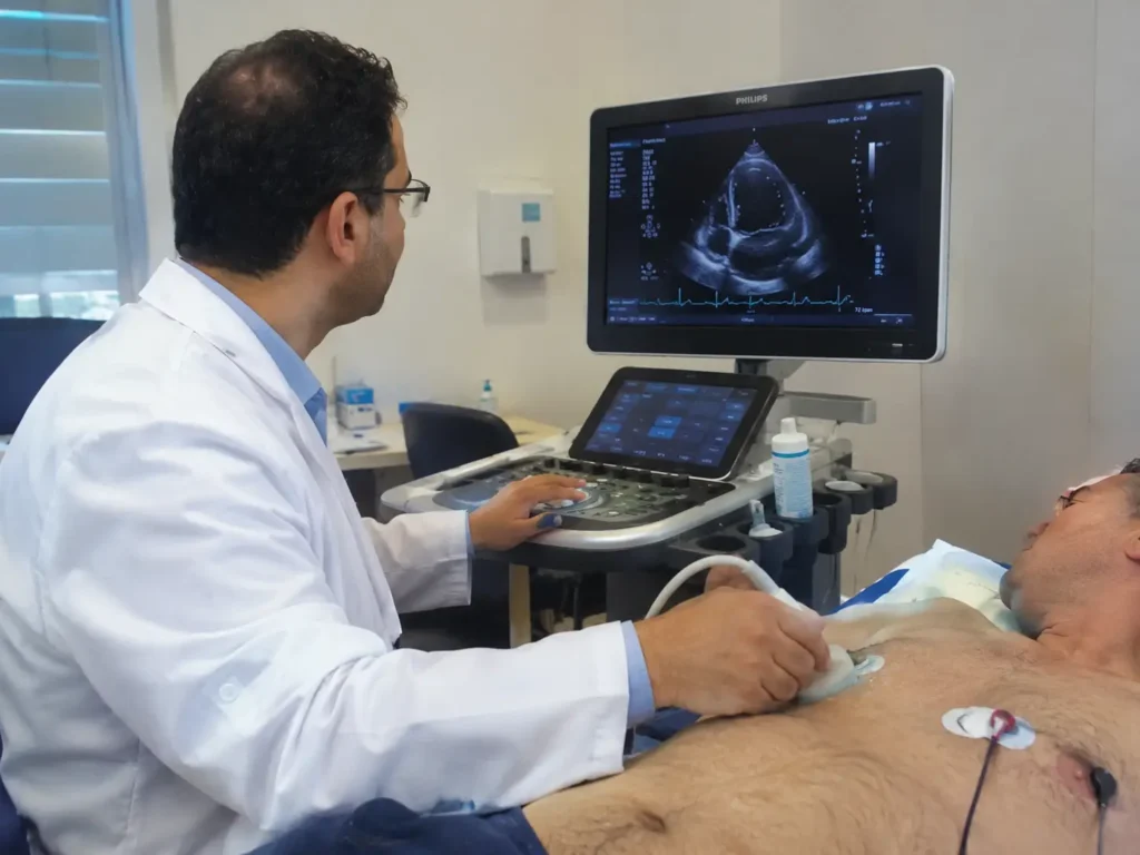 Cardiologue réalisant une échographie cardiaque sur un patient dans une salle de consultation à la Clinique Assalam à Tanger.